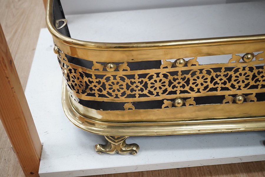 An early 19th century brass fender with pierced decoration, 91cm wide. Condition - fair to good